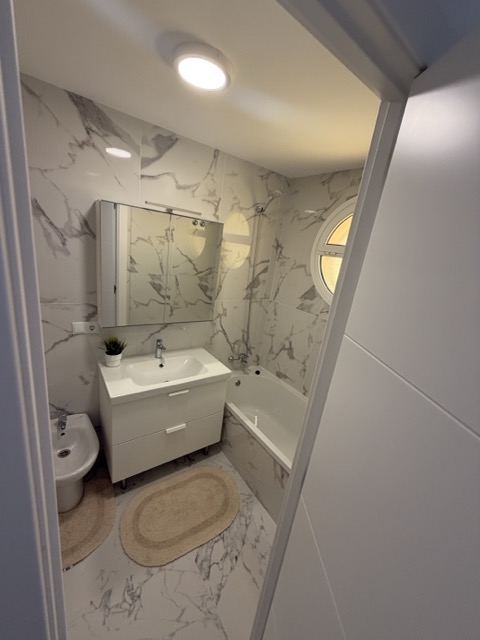Marble bathroom with bathtub and porthole window