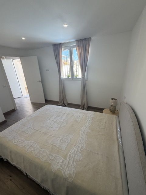 Master bedroom with curtained window and natural light